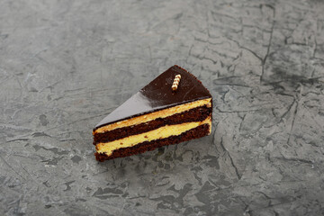 dessert chocolate cake in glaze on a gray concrete background