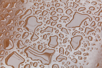 A brown surface with water droplets scattered all over it