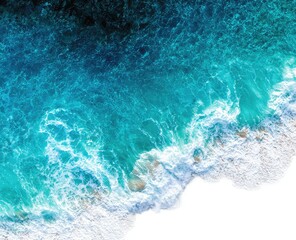 High-angle view of turquoise ocean waves crashing on a sandy beach