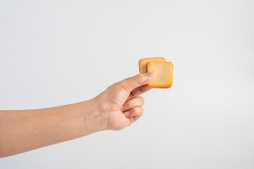 Square crispy snack in hand on white background