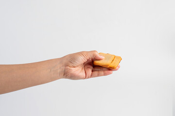 Square crispy snack in hand on white background