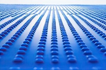 Close-up of a blue, textured surface with rows of raised circles
