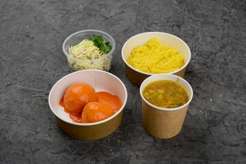 lunch soup, mashed potatoes, meatballs and salad on a gray background