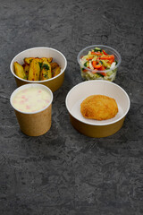 lunch cheese cream soup with fried potato cutlet and salad on a gray background