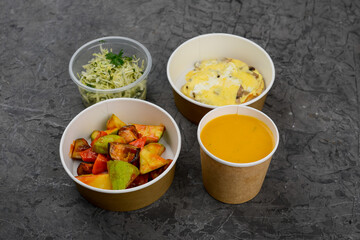 lunch pumpkin cream soup with roasted vegetables and salad on a gray background