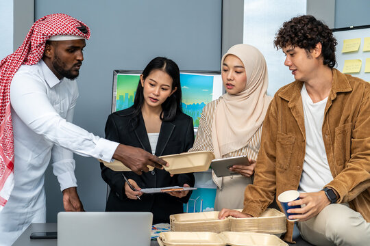 Group of multicultural business people in a discussion reusable product, implementing environmental protection, using whiteboards and presentation materials, eco-friendly packaging