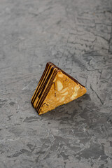 dessert honey cake covered with icing on a gray concrete background