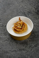wheat porridge with caramelized onions in a disposable dish