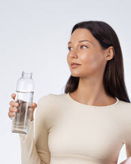 Healthy Woman Holding Water Bottle Looking Away On Clean Studio Background