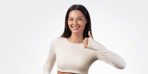 Happy Woman in Beige Fitness Set Giving Thumbs Up for Wellness Concept