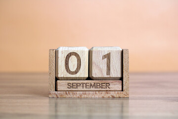 Wooden perpetual calendar showing september 1st on orange background