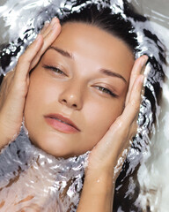 Woman Touching Face While Floating In Water With Soft Light And Calm Look
