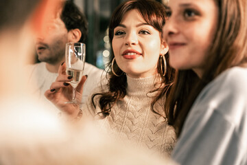 A joyful group of diverse friends laughing and toasting at a Christmas party. Multi-ethnic people sharing a happy moment with sparkling wine during a festive holiday gathering.