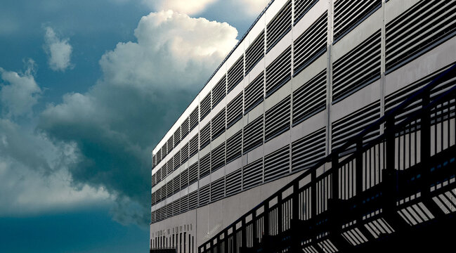 Ventilation facade on cloudy day. Modern architectural wall with metal slats, louver panels,