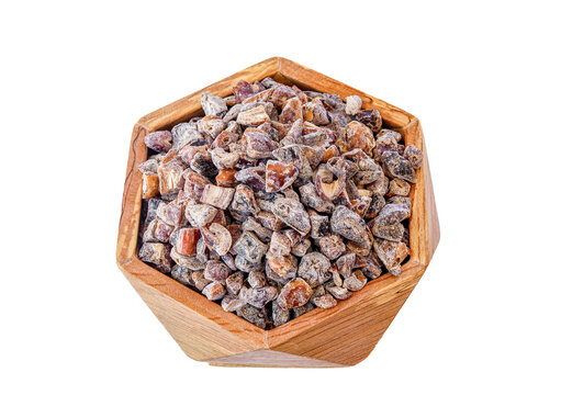 A rectangular plastic container filled with mixed traditional nuts, raisins, dried figs, and possibly pieces of rock candy. The medley has a rich, rustic appearance with various shades of brown, beige
