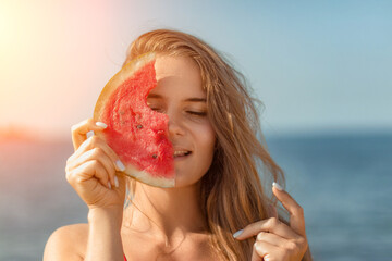 Watermelon Beach Summer: Woman playfully covers face with watermelon slice, enjoying sunny day at...