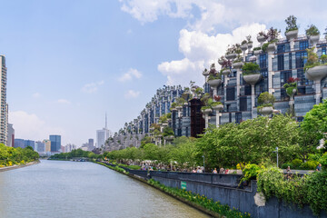 Shanghai. This picturesque view features contemporary buildings alongside a serene river in Shanghai, emphasizing urban nature.