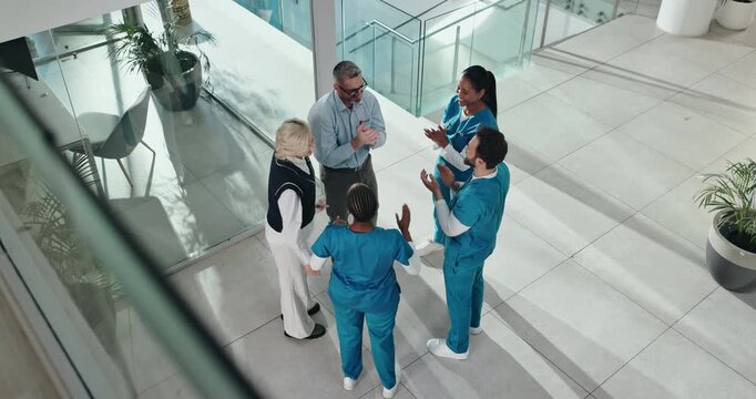 Above, doctors and people in hospital, applause and success with medical milestone. Group, healthcare service and employees in clinic, clapping and celebration with happiness, smile and teamwork