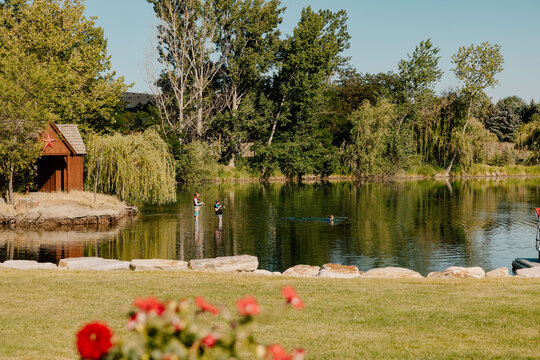 Teenage boys fishing and swimming in a serene lake