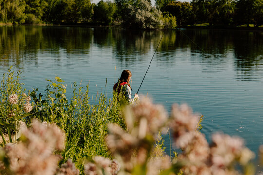 Young man fishing on lake enjoying peaceful day