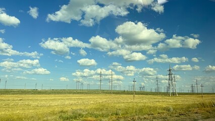 Many high-voltage transmission tower and electricity pylon power lines against blue sky with cloud
