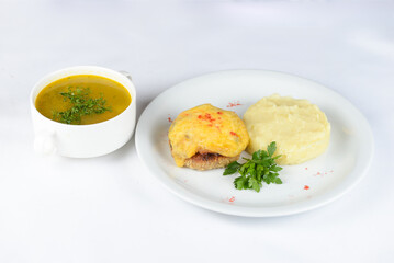 lunch soup with potatoes and cutlet with cheese on a white background