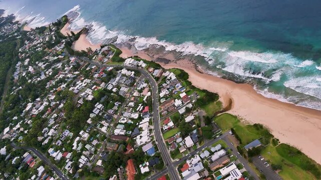 South Coast, NSW, Australia: Drone UHD Video -Dynamic aerial shots of waves over Thirroul beaches, flying over holiday homes, golden sand and sparkling blue waters.