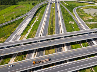 Drone shot a large highway interchange crossing over green farmlands in Thailand