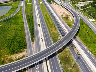 Drone shot a large highway interchange crossing over green farmlands in Thailand