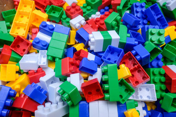 A multicolored plastic building blocks scattered randomly. Ideal for background, childhood, education, toys, imagination, and creativity