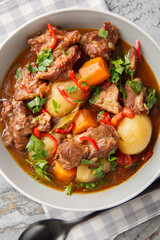 Semur daging or Meat beef with sweet soy sauce and vegetables closeup in the bowl on the table. Vertical top view from above