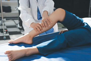 Female doctor hands doing physical therapy By extending the leg and knee of a male patient