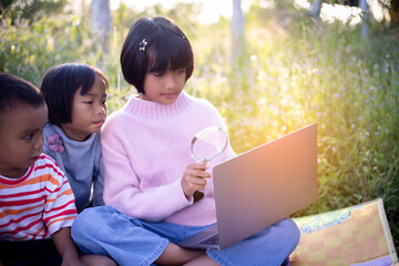 Kids exploring in forest with a magnifying glass