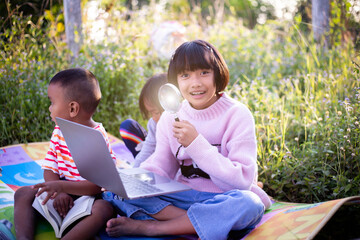 Kids exploring in forest with a magnifying glass