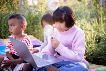Kids exploring in forest with a magnifying glass