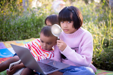 Kids exploring in forest with a magnifying glass