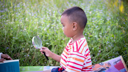 Kids exploring in forest with a magnifying glass