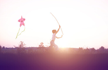 Child flying a multicolored kite outside