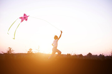 Child flying a multicolored kite outside