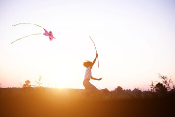Child flying a multicolored kite outside