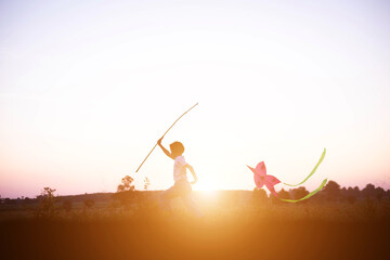 Child flying a multicolored kite outside