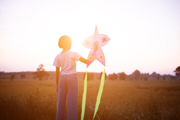 Child flying a multicolored kite outside