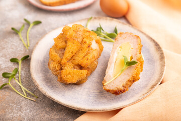 Chicken schnitzel on blue plate with microgreen on brown concrete. Diet, healthy eating. side view, selective focus