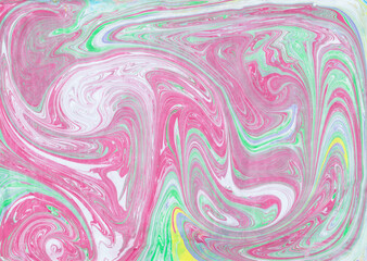 Abstract pink green ebru background. Bright iridescences of paint on the water. A creative artistic background for graphic design. Multi-colored shades of colors mixing. Fluid texture Contemporary art
