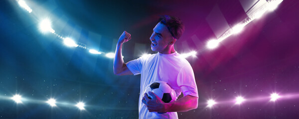 Male soccer player excited after game holding ball under 3D stadium lights. Concept of summer...