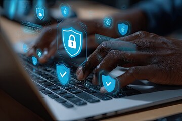 Close-up of hands typing on laptop, security icons overlay
