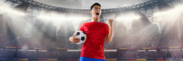 Football player in red shirt celebrating with ball in crowded 3D stadium. Concept of summer sport,...
