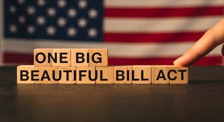 Wooden blocks spell out one big beautiful bill act with american flag background