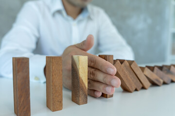 insurance with hands protect domino. Businessman hands stop dominoes falling in business crisis. business risk control and planning and strategies to run prevent insurance businesses.