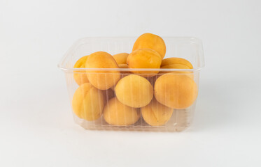 apricots in a transparent container on a white background